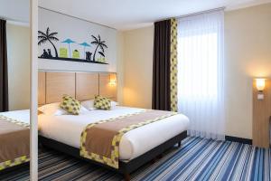une chambre d'hôtel avec un lit et une fenêtre dans l'établissement The Originals Boutique, Actuel Hôtel, Saint-Etienne Aéroport, à Andrézieux-Bouthéon 49 autres photos