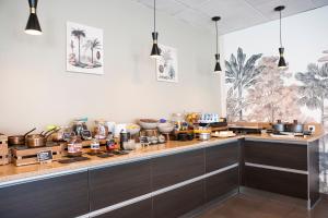 une cuisine avec un comptoir avec des casseroles et des poêles dans l'établissement The Originals Boutique, Actuel Hôtel, Saint-Etienne Aéroport, à Andrézieux-Bouthéon