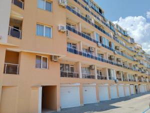 an apartment building with garages in front of it at Comfy Home in Pomorie