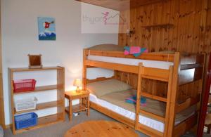 a bedroom with two bunk beds and a table at Chalet Zou Derri 3 in Les Collons