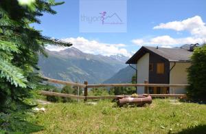 a house with a fence and a view of a mountain at Chalet Zou Derri 3 in Les Collons +3 photos