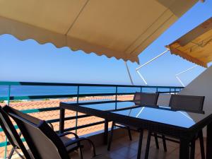 a balcony with a table and chairs and the ocean at Apartment Kanali The best view in Kanali