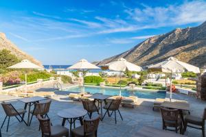 a patio with tables and chairs and a pool at Xerolithia in Kamares