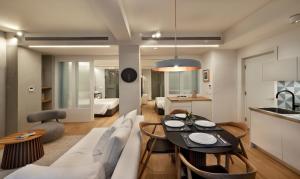 a kitchen and living room with a table and a couch at AIONION RESIDENCES by K&K in Athens
