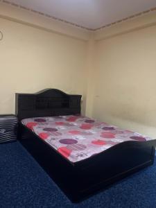 a bedroom with a bed with a red and black quilt at Lama home in Bālāju