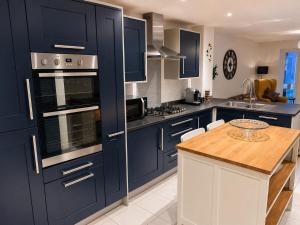 a kitchen with blue cabinets and a wooden table at Harwell Haven Large 4BR Home Garden & Parking in Chilton