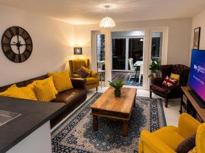 a living room with yellow furniture and a table at Harwell Haven Large 4BR Home Garden & Parking in Chilton