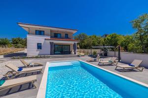 a swimming pool with chairs and a house at Villa ADRIA MOMENTS with private pool in Pinezici