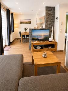 a living room with a couch and a tv at Strandschlösschen in Kühlungsborn