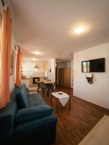 a living room with a blue couch and a table at Istrian old town apartment in Koper