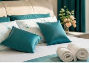a bed with blue pillows and towels on it at Ap Blessedplace Rîșcani-New Bldg in Chişinău