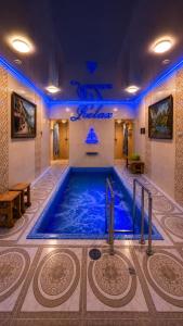 a large swimming pool in a room with blue lighting at Delmont hotel in Kostanay