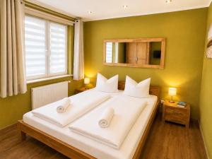 a bedroom with a large white bed with a window at Strandschlösschen in Kühlungsborn