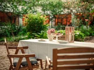 a white table with a vase of flowers on it at Kuća za odmor Weinrauch in Ilok