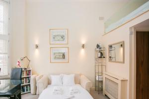 a white room with a bed and a shelf at Modern 1 bed Flat in Knightsbridge in London