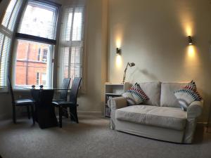a living room with a white couch and a table at Modern 1 bed Flat in Knightsbridge in London