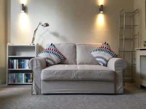 a white couch with two pillows in a living room at Modern 1 bed Flat in Knightsbridge in London +26 photos