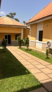 a walkway in front of a house with palm trees at NBTE Hotels in Kaduna +11 photos