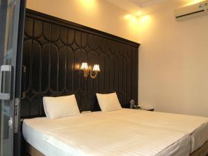 a bedroom with a large bed with a black headboard at Ánh Sao in Ha Long