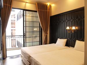 a bedroom with a large bed and a large window at Ánh Sao in Ha Long