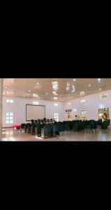 a large room with chairs and a projection screen at NBTE Hotels in Kaduna