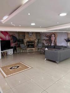a living room with a couch and a painting of a woman at Regent Palace Hariz Hotel in Aley