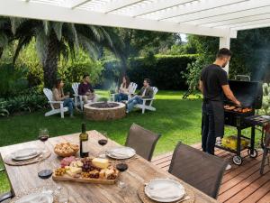 a man standing next to a table with a grill at Swannie Creek private nature retreat with hot tub and fireplace in Grabouw