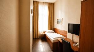 a hotel room with a bed and a television at Hotel AI Königshof in Berlin