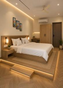 a bedroom with a large white bed and wooden floors at Hotel shivay inn in Indore