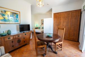 a dining room with a table and a tv at Monte da Bravura Green Resort in Bensafrim