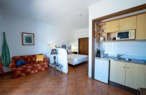 a living room with a couch and a kitchen at Monte da Bravura Green Resort in Bensafrim