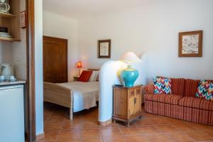 a living room with a bed and a couch at Monte da Bravura Green Resort in Bensafrim