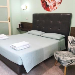 a bedroom with a large bed and a chair at Piazza Verdi Liberty House in Lecce