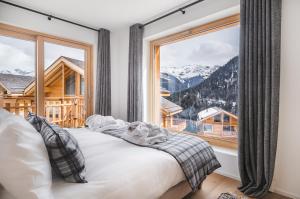 a bedroom with a bed and a large window at Guernerés & Spa by Alpine Resorts in Grimentz +275 photos
