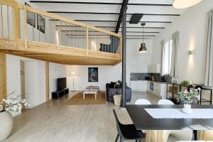 a living room and kitchen with a staircase in a loft at Kenzingen Appartements zur Alten Brauerei in Kenzingen