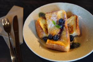 a plate of french toast with blueberries and syrup at Masukichi -hostel,cafe,souvenir,guide- in Seto