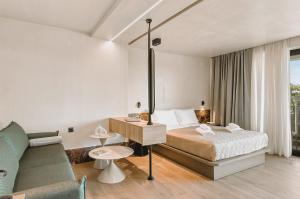 a hotel room with a bed and a couch at MAHA Her City Living by Semavί in Heraklio