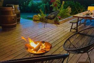 a fire pit on a deck with a table and chairs at Havre de paix in Péreuil