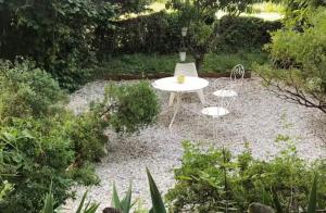 a white table and two chairs in a garden at Havre de paix in Péreuil +1 photo
