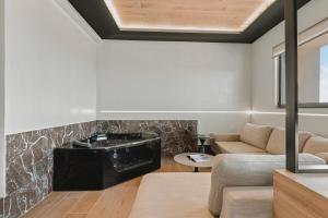 a living room with a fireplace and a couch at MAHA Her City Living by Semavί in Heraklio