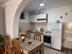 a kitchen with a table and a white refrigerator at Studio Apartman Đurđevak 2 in Banja Koviljača +7 photos