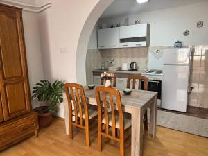 a kitchen with a table and chairs and a white refrigerator at Studio Apartman Đurđevak 2 in Banja Koviljača