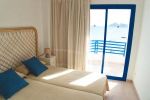 a bedroom with a bed with a view of the ocean at Apartamentos la barca in Benidorm