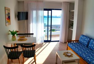 a living room with a couch and a table with chairs at Apartamentos la barca in Benidorm