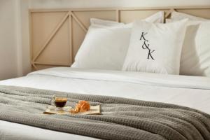 a tray of food and a drink on a bed at AIONION RESIDENCES by K&K in Athens +108 photos