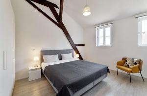 a bedroom with a large bed and a chair at Kenzingen Appartements zur Alten Brauerei in Kenzingen +19 photos