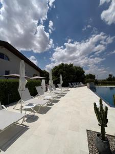 a row of lounge chairs and a swimming pool at Villa dei tigli - Altamura in Altamura