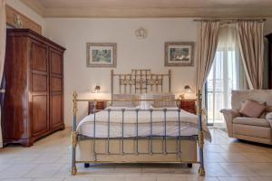 a bedroom with a bed and a couch and a chair at Valleyside Heights Residence - Pool & Heated Jacuzzi in Is-Swieqi +205 photos