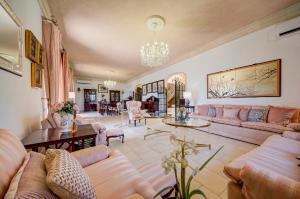 a living room with pink couches and a table at Valleyside Heights Residence - Pool & Heated Jacuzzi in Is-Swieqi