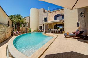 a swimming pool in front of a house at Valleyside Heights Residence - Pool & Heated Jacuzzi in Is-Swieqi